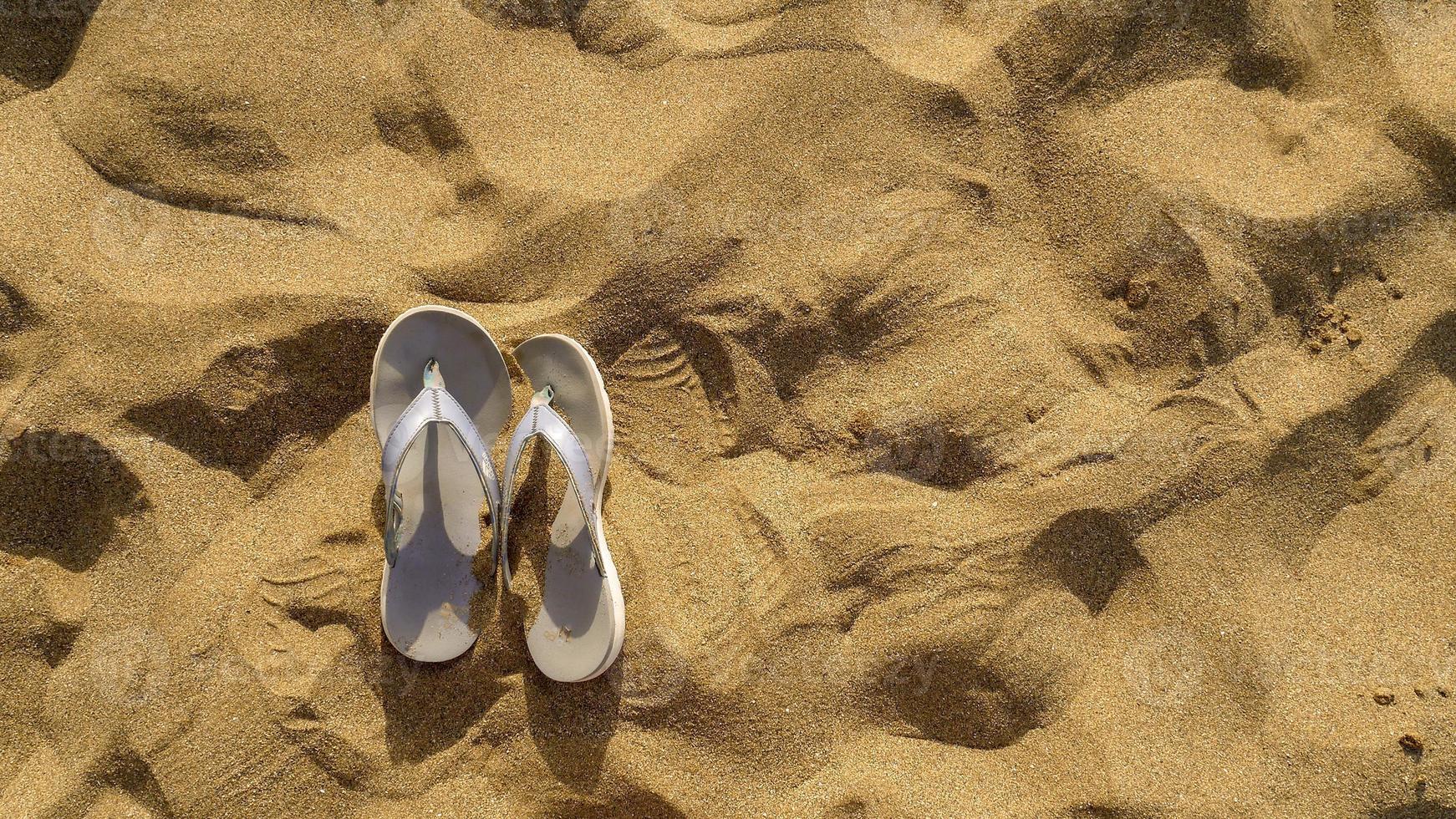 sable et sandales sur le fond de la plage photo