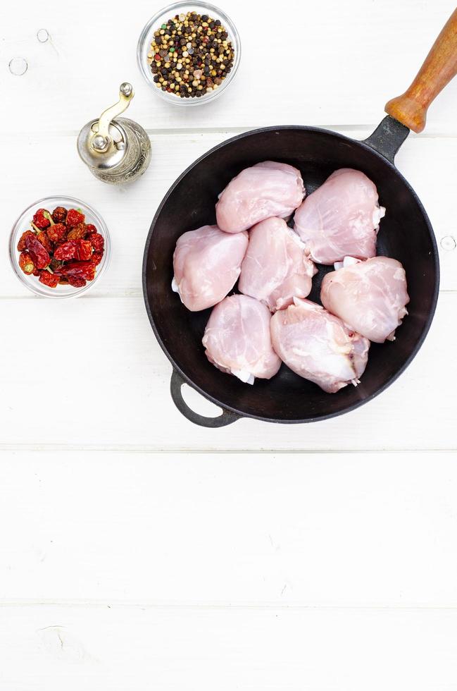 morceaux crus de cuisse de poulet dans une poêle pour la cuisson. photo d'atelier.