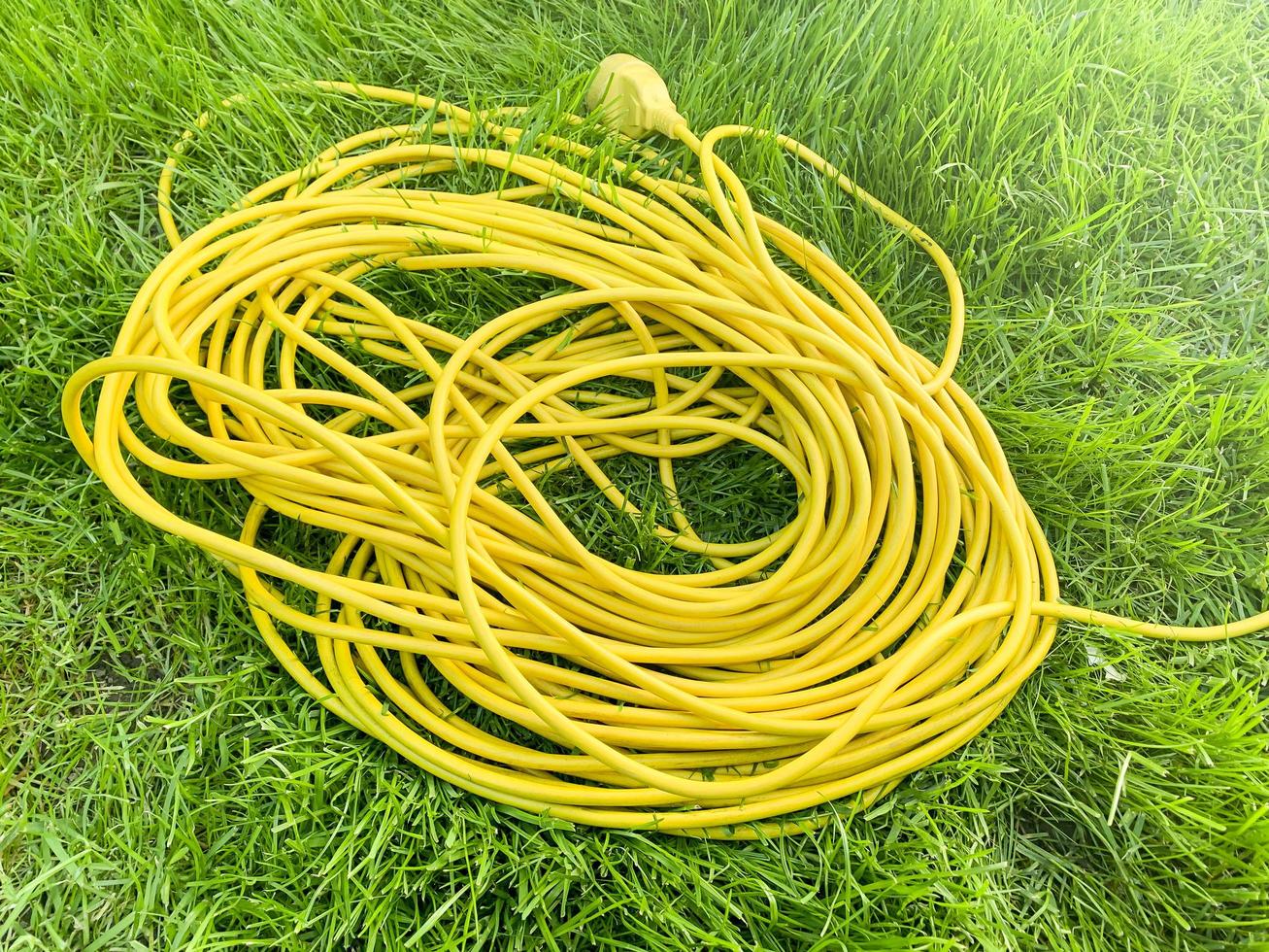 câble électrique jaune sur l'herbe verte. photo