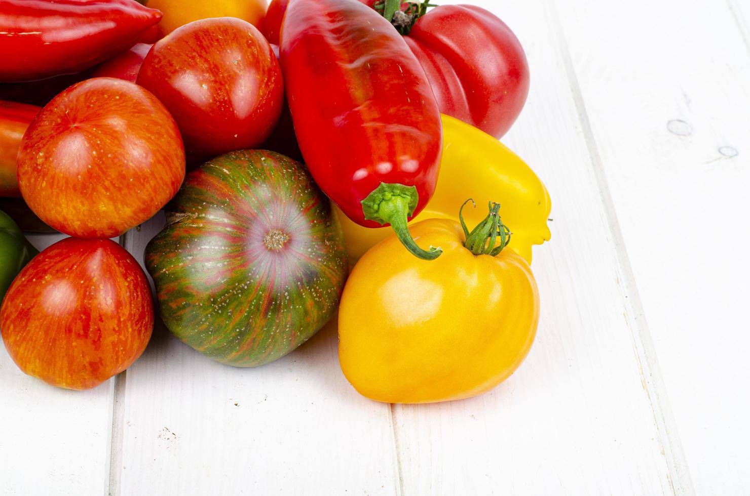 poivrons et tomates multicolores sur table en bois. photo d'atelier.