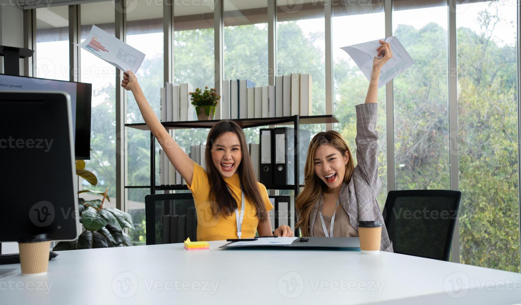 asiatique intelligent Bureau ou femme d'affaires excité réussi affaires personnes, célébrer gagner. deux femme d'affaires à la recherche à une mensuel sommaire de Ventes cette dépasser Ventes cibles et atteindre rentable croissance photo