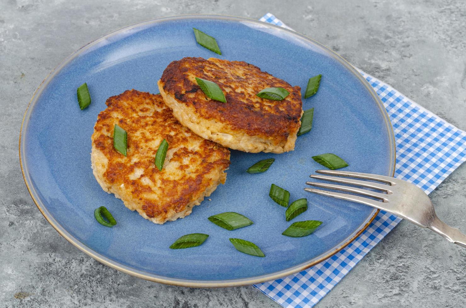 assiette bleue avec deux escalopes de viande hachée. studio photo