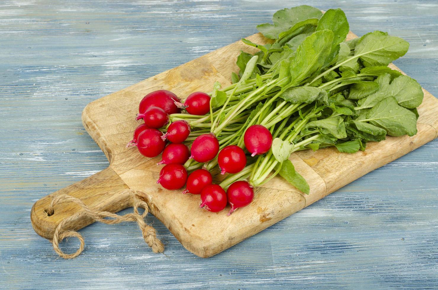 bouquet de radis frais sur une planche à découper en bois de cuisine. studio photo