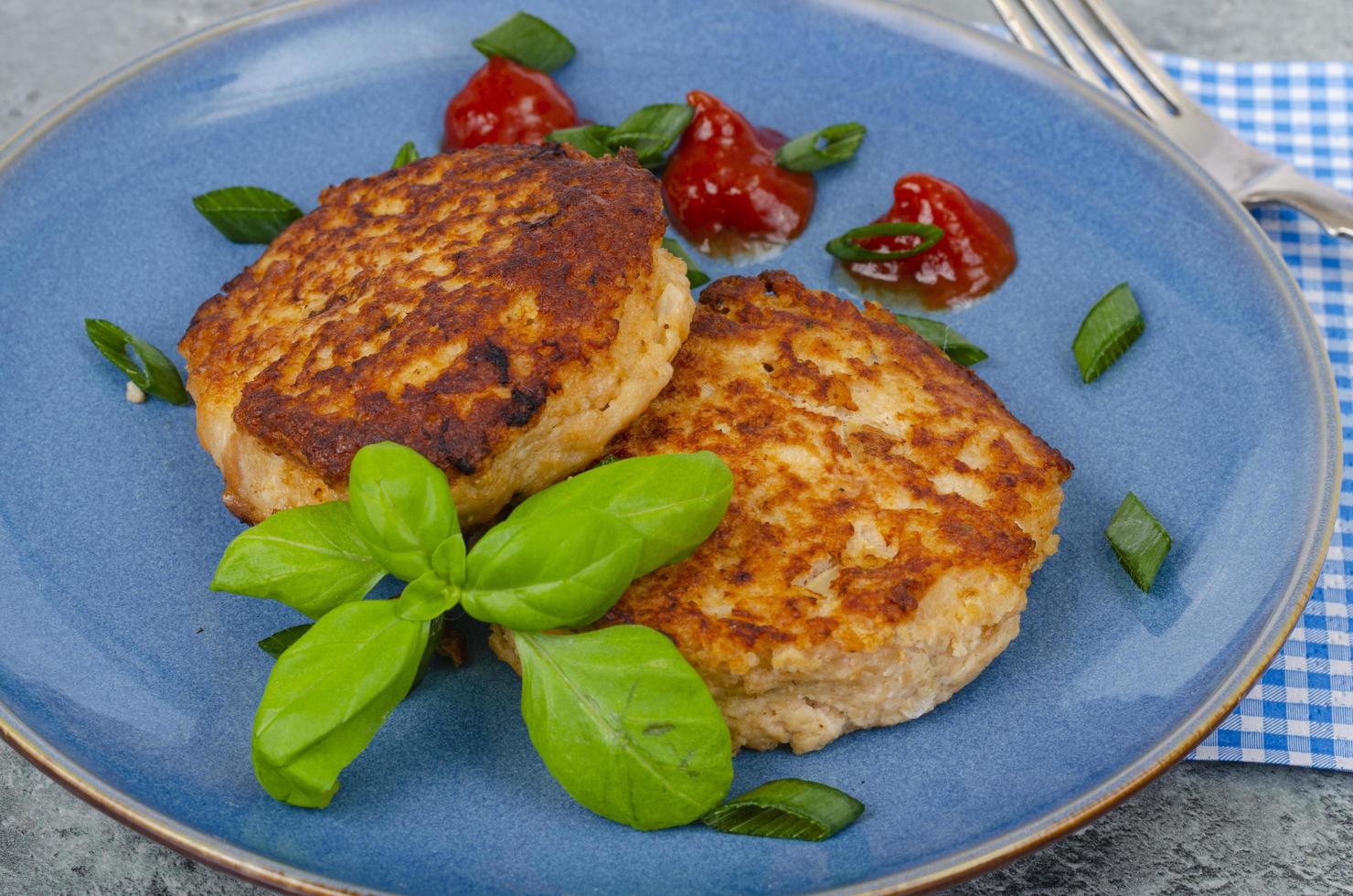 assiette bleue avec deux escalopes de viande hachée. studio photo