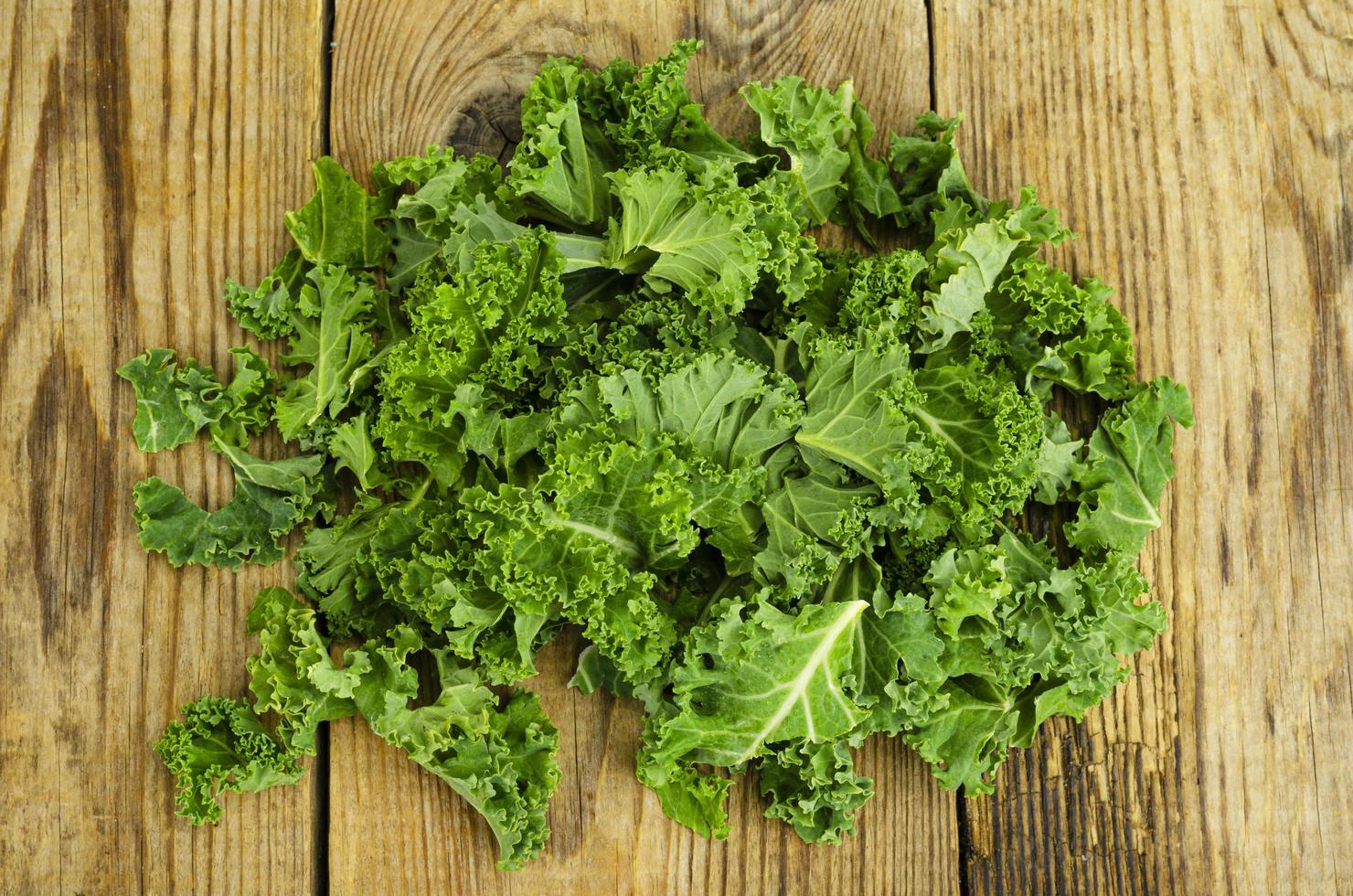 feuilles de sabellica vertes fraîches sur fond en bois, aliments biologiques sains. photo