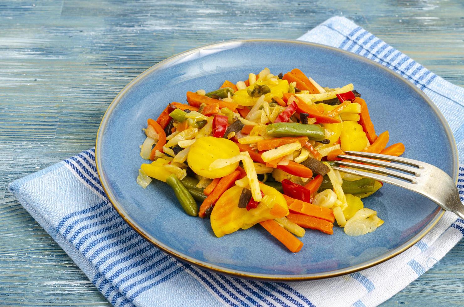 mélange de légumes bouillis dans des aliments diététiques, fond bleu. photo