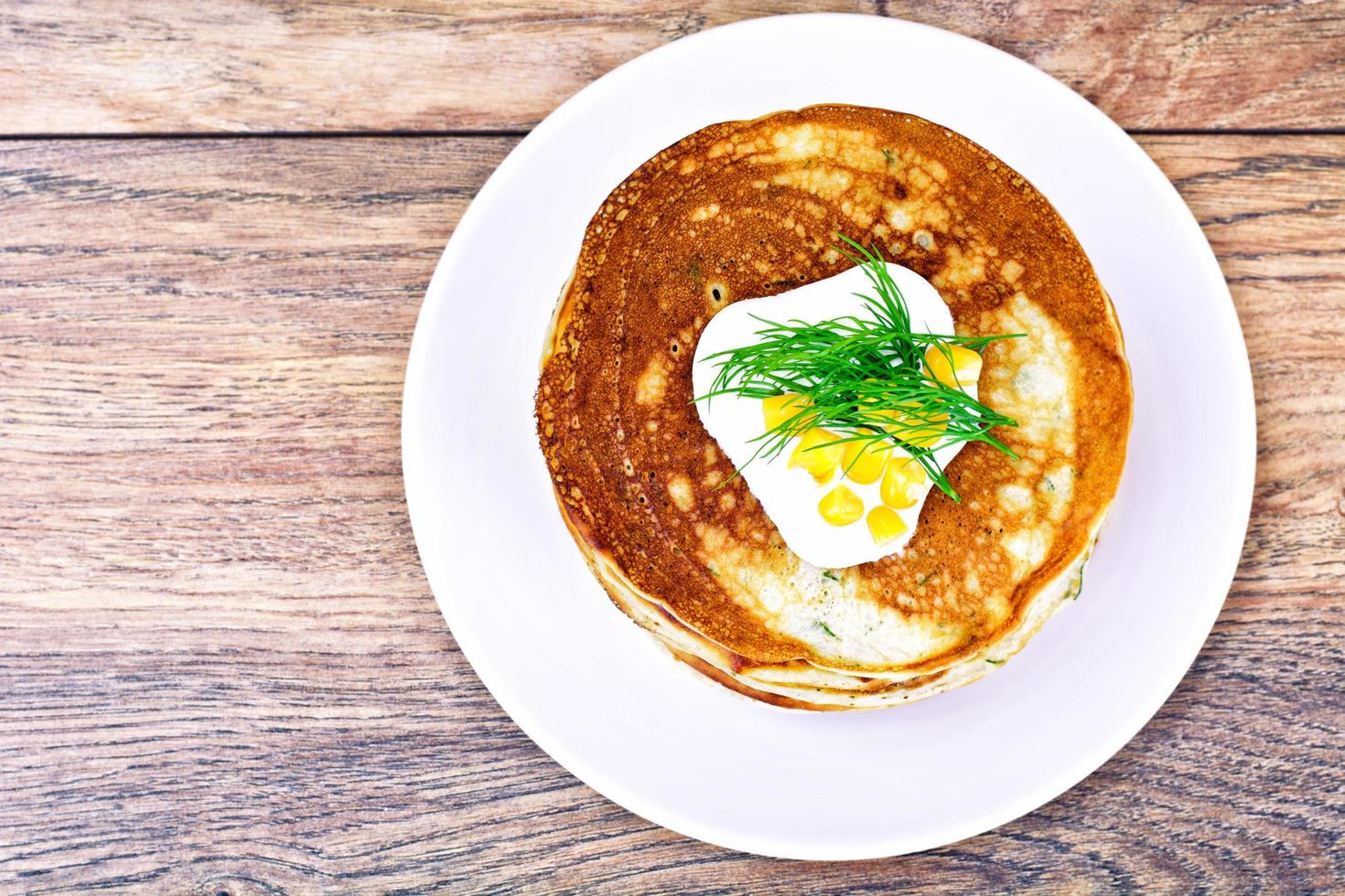 pile de crêpes savoureuses avec du maïs sucré photo