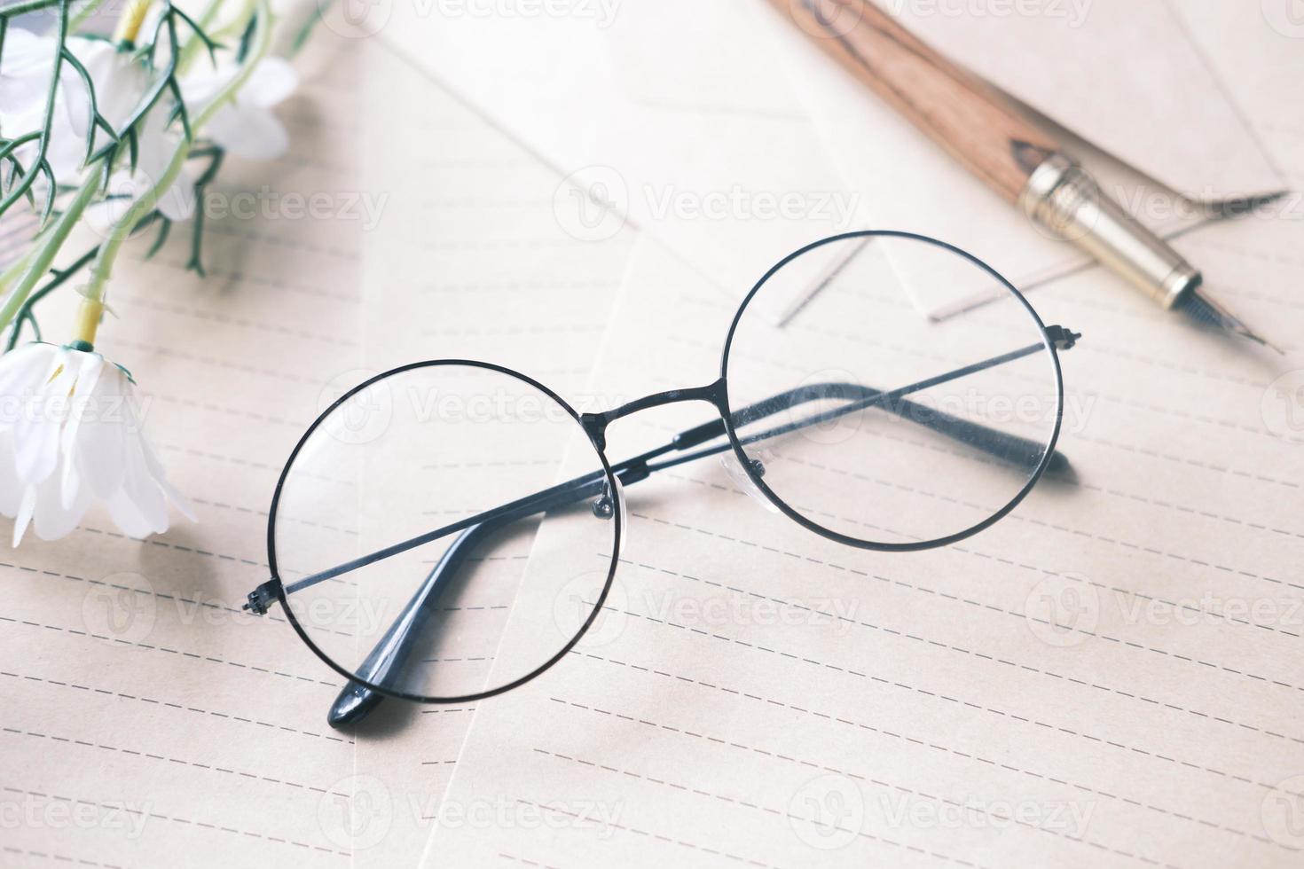 bloc-notes, lunettes et crayon sur table en bois photo