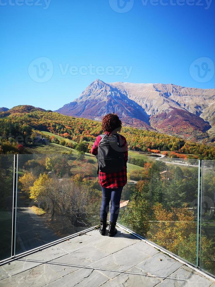 touriste admire la montagne vettore en automne dans le parc sibillini photo