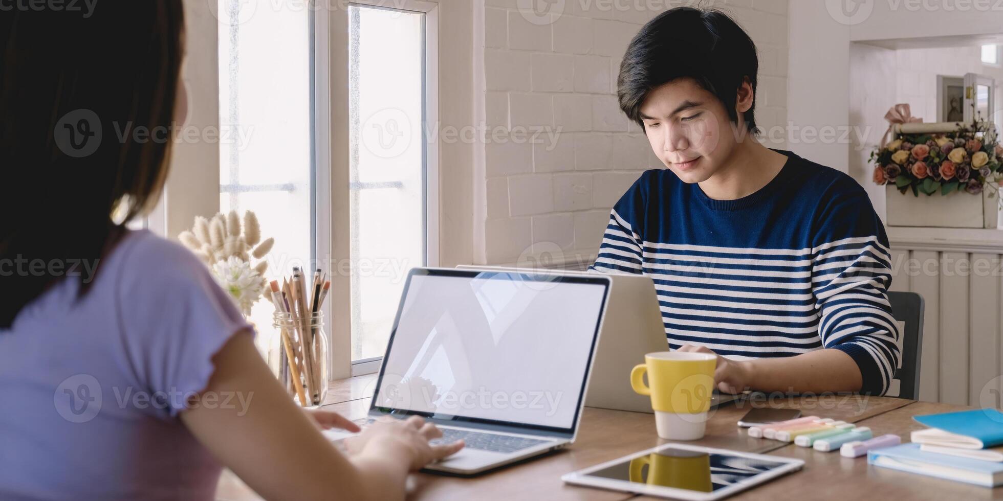 asiatique étudiant concentrer apprentissage en ligne cours et en train de regarder Didacticiel via portable ordinateur à vivant pièce dans maison,. en ligne classe pièce concept. photo