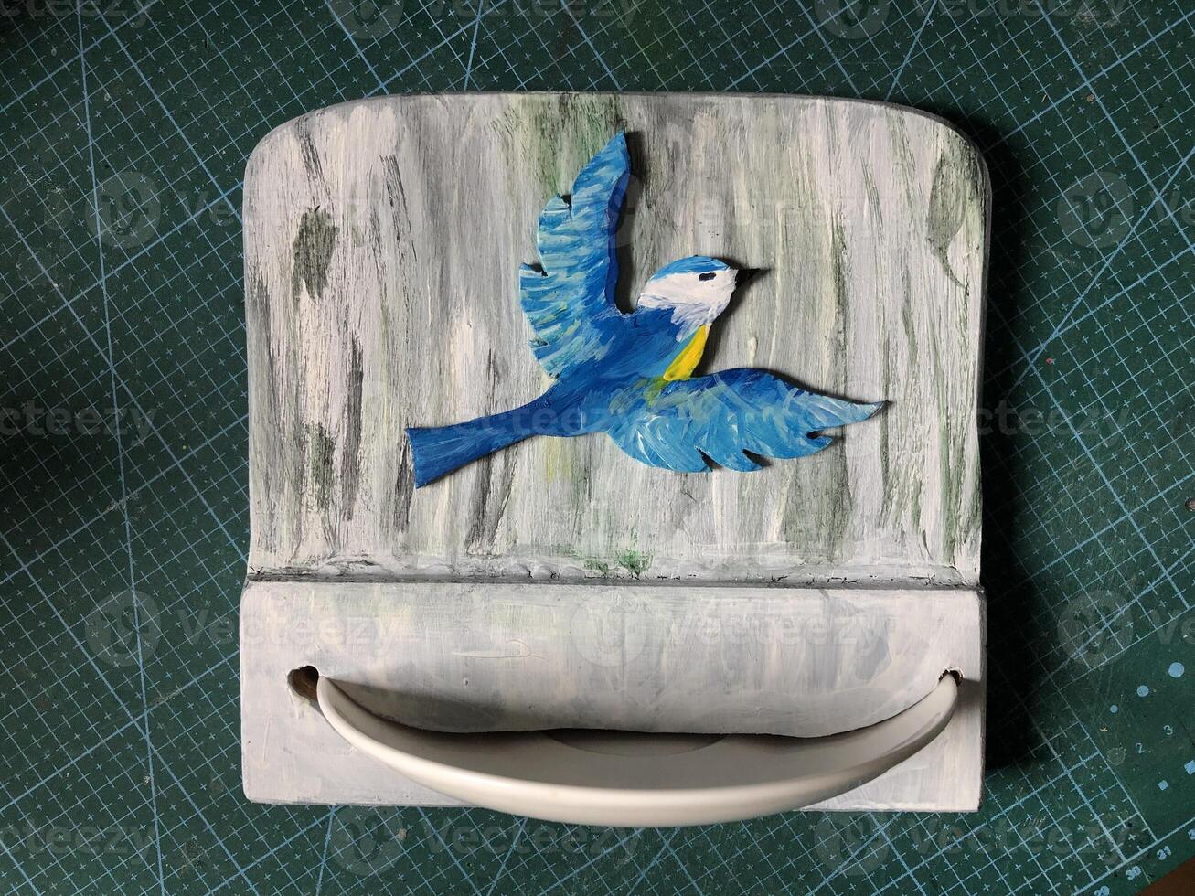 Nouveau fait maison oiseau mangeoire, convexe silhouette dessin de une mésange, porcelaine plaque, gris texturé Contexte photo