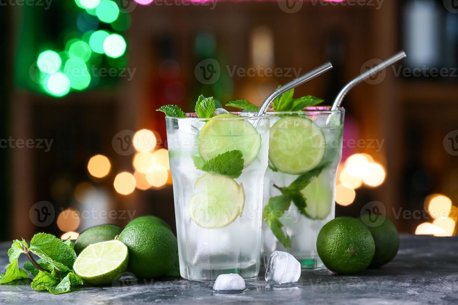 verres de mojito froid sur table contre les lumières floues photo