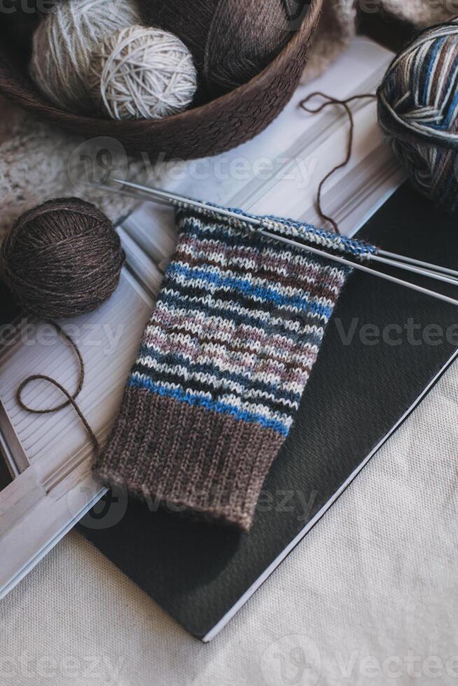 main tricoté chaussettes avec aiguilles et fil des balles. concept pour Fait main et hygge lent vie. photo