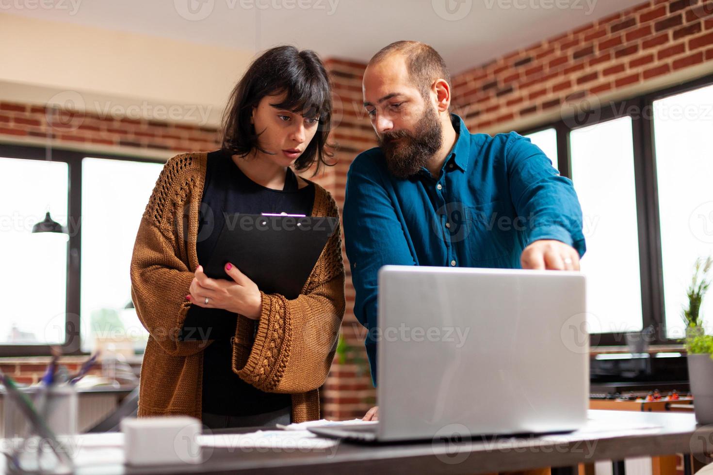 homme d'affaires expliquant des idées de marketing à une femme gestionnaire montrant le débit de données sur un ordinateur portable photo