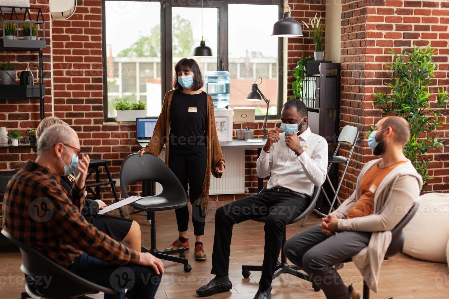 femme avec un masque facial parlant de problèmes lors d'une séance de thérapie de groupe avec des gens photo