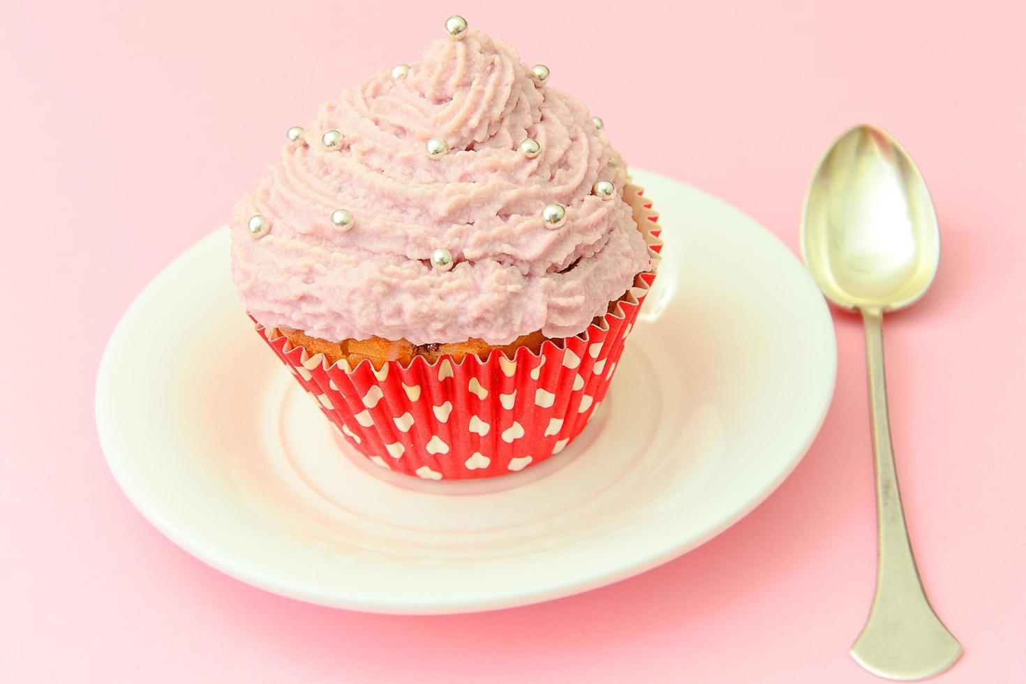 gâteau à la crème, cupcake sur fond rose. photo