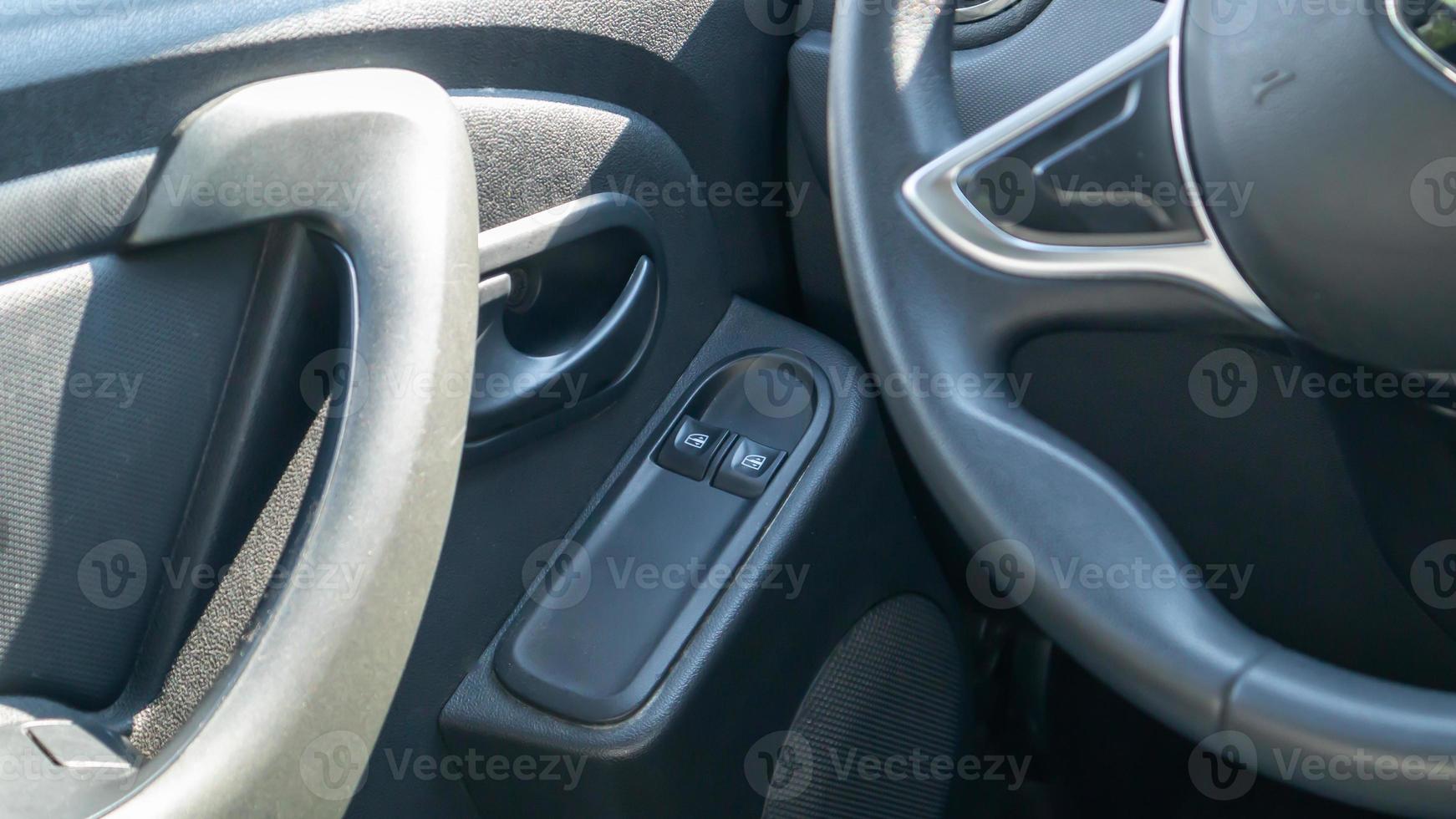 les boutons des vitres électriques avant et arrière abaissent ou ferment les vitres de la voiture. éléments et commandes de vitres de voiture. détailler la voiture. détails intérieurs de la poignée de porte avec commandes de vitres électriques. photo