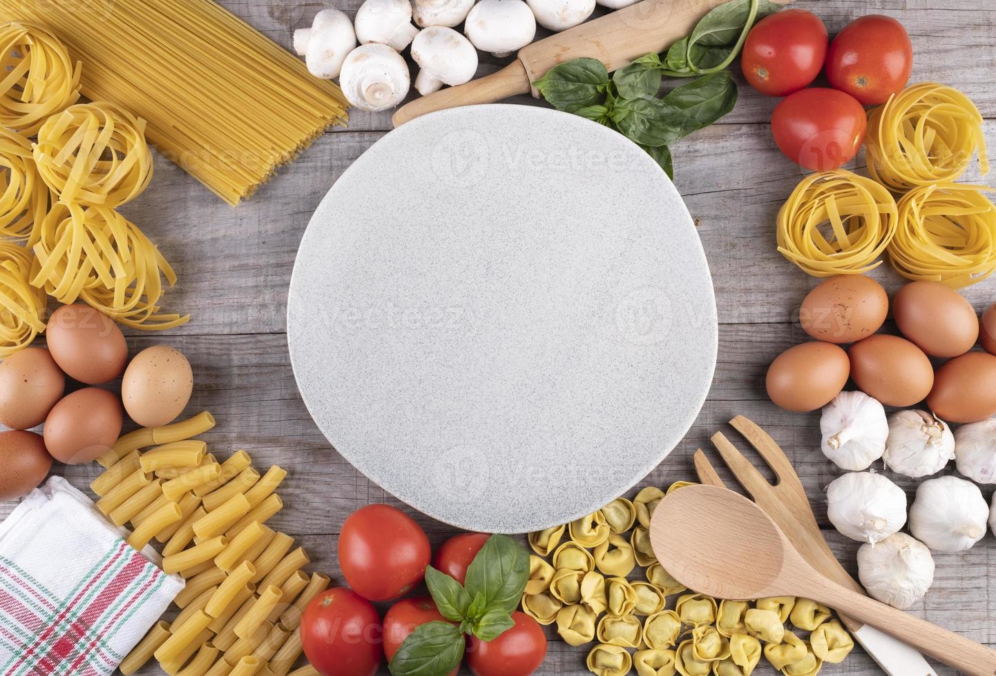 pâtes, légumes, œufs, avec plat au milieu sur planche de bois photo