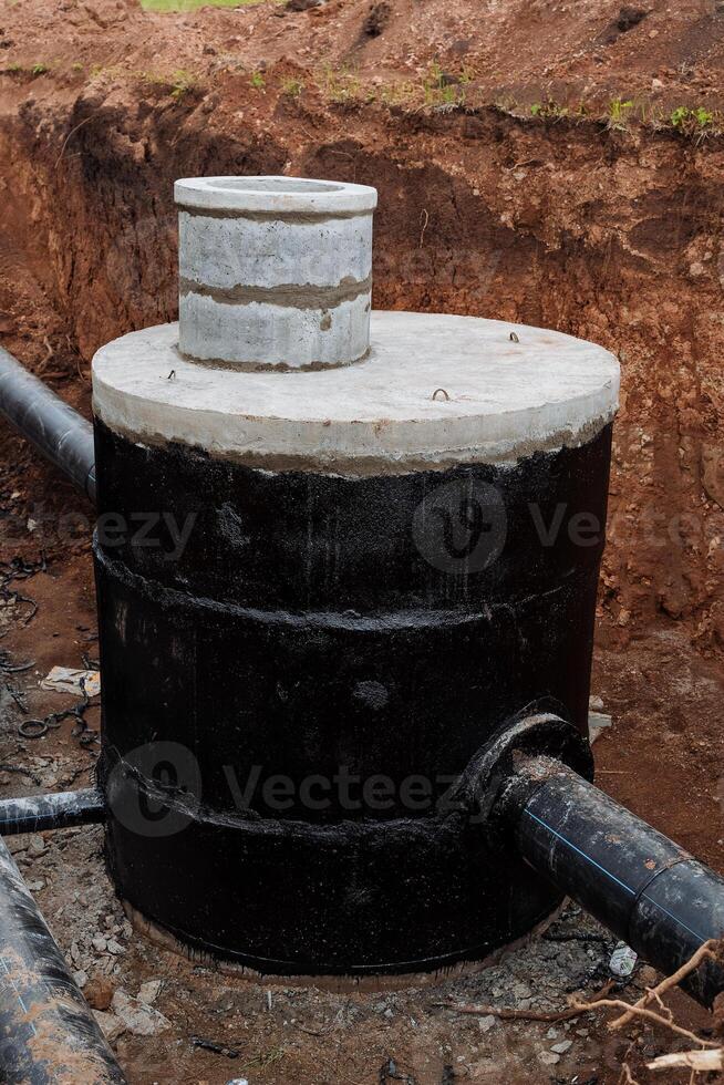 bien fosse, renforcé béton Bien, gris béton anneaux, assainissement à le bas de le argile fosse, pipeline. photo