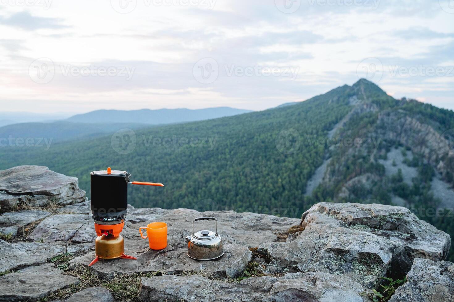 petit déjeuner de une touristique sur une Montagne pente, une ensemble de vaisselle pour cuisine dans la nature sur une randonnée. Orange thé tasse. photo