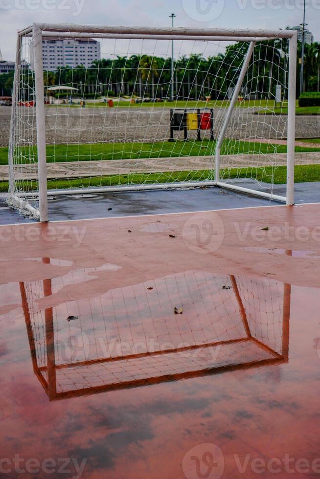 flaques d'eau de l'eau sur le futsal champ objectif après pluie. photo