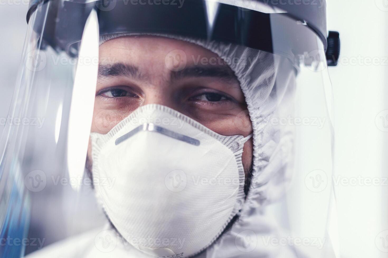 proche en haut de porter en dehors médical ingénieur portant visage masque et ppe costume. surmené chercheur habillé dans protecteur costume contre invection avec coronavirus pendant global épidémie. photo