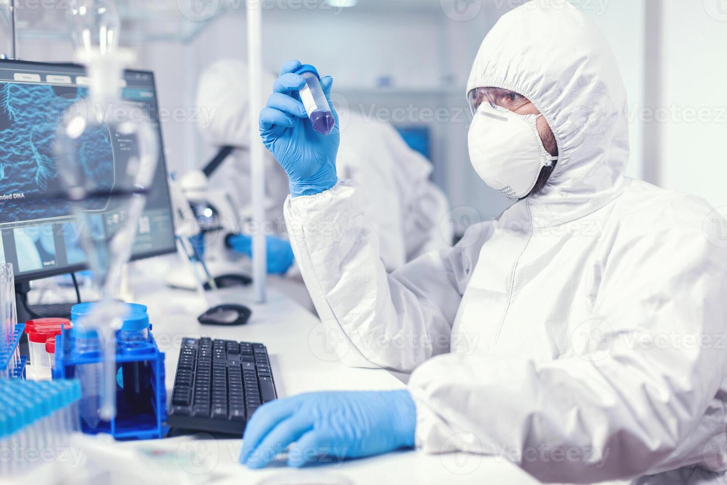 laboratoire technicien habillé dans protecteur costume comme sécurité précaution à la recherche à tester tube. scientifique dans laboratoire portant combinaison Faire recherche et en cours d'analyse substance pendant global pandémie avec COVID-19 [feminine. photo