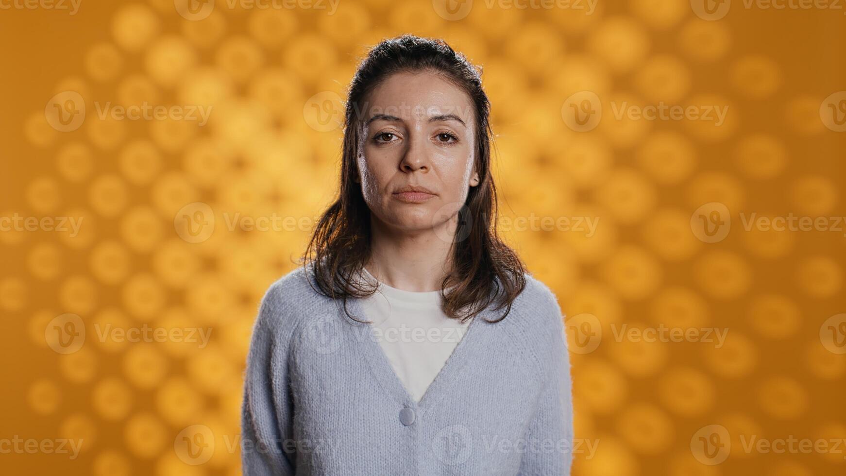 portrait de détendu femme poser, à la recherche à caméra, isolé plus de Jaune studio Contexte. caucasien la personne habillé dans décontractée tenue debout, sentiment confiant, caméra b photo