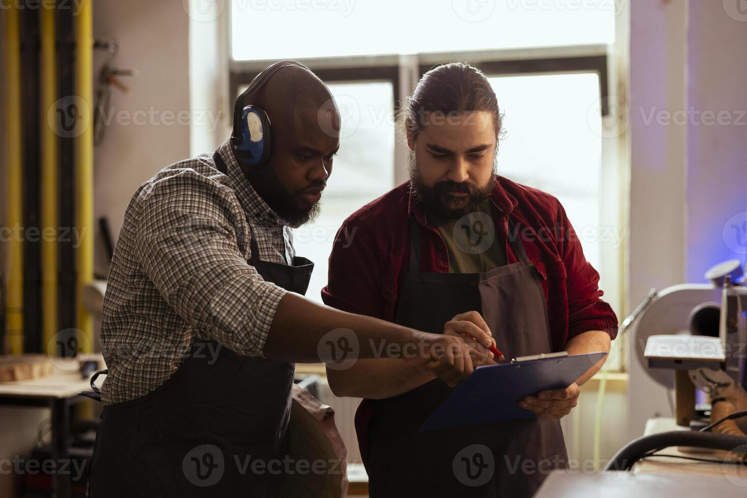 Charpentier et collaborateur à la recherche plus de technique dessins sur bloc-notes à faire Créatif bois art pièces. artisan et africain américain homme à la recherche à plans à exécuter travail du bois projets photo