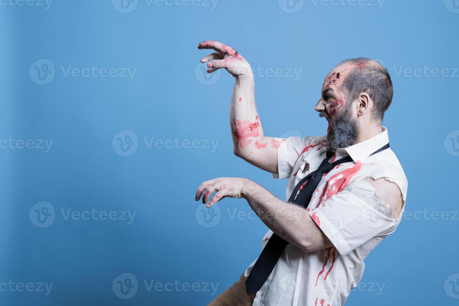 affamé Mort-vivant zombi sifflant et à la recherche pour Humain cerveaux, hanté victimes. en marchant mort cadavre recherche pour la chair à consommer, en train de préparer pour attaque avec mains agissant comme les griffes, studio Contexte photo