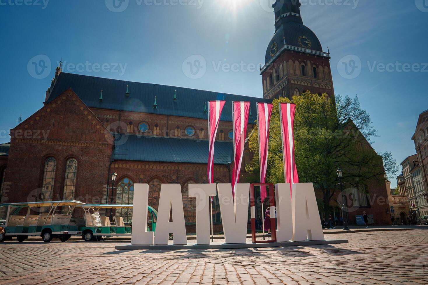 ensoleillé journée dans vieux ville riga avec Lettonie signe et chariot autobus photo