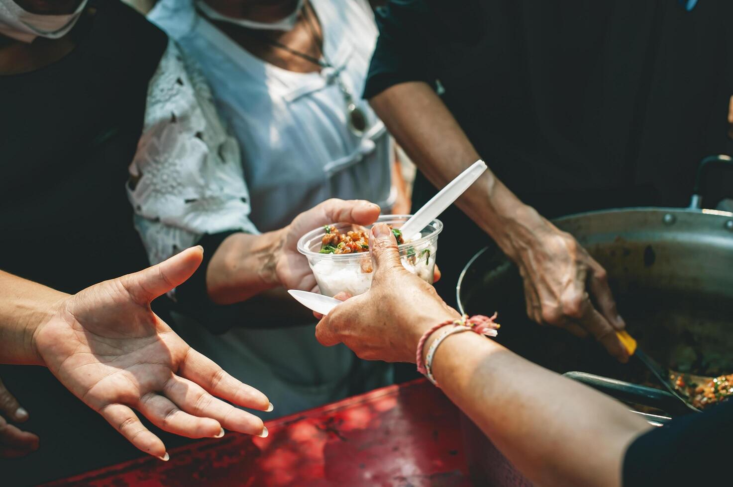bénévoles partager nourriture aide avec le pauvres dans le communauté. photo