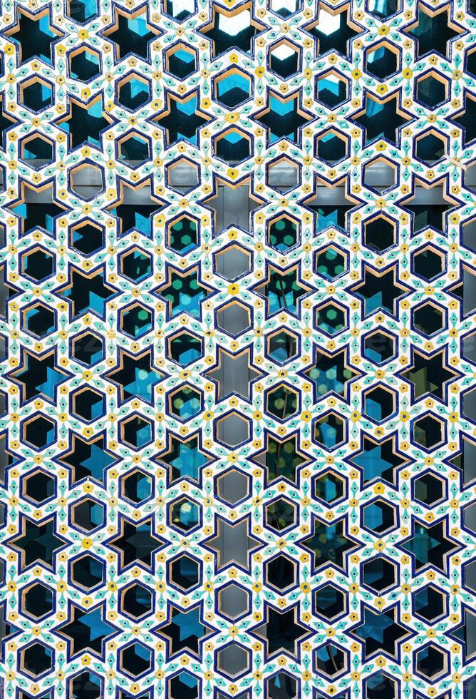 le fenêtre de une musulman mosquée derrière bars dans le forme de une géométrique hexagonal islamique ornement. photo