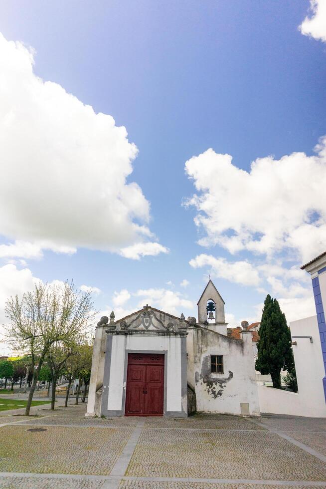 arraiolos, alentejo, le Portugal. Mars 29, 2023. iconique Arriaolos chapelle des stands en dessous de une ciel rempli avec flottant blanc des nuages dans alentejo, le Portugal. photo