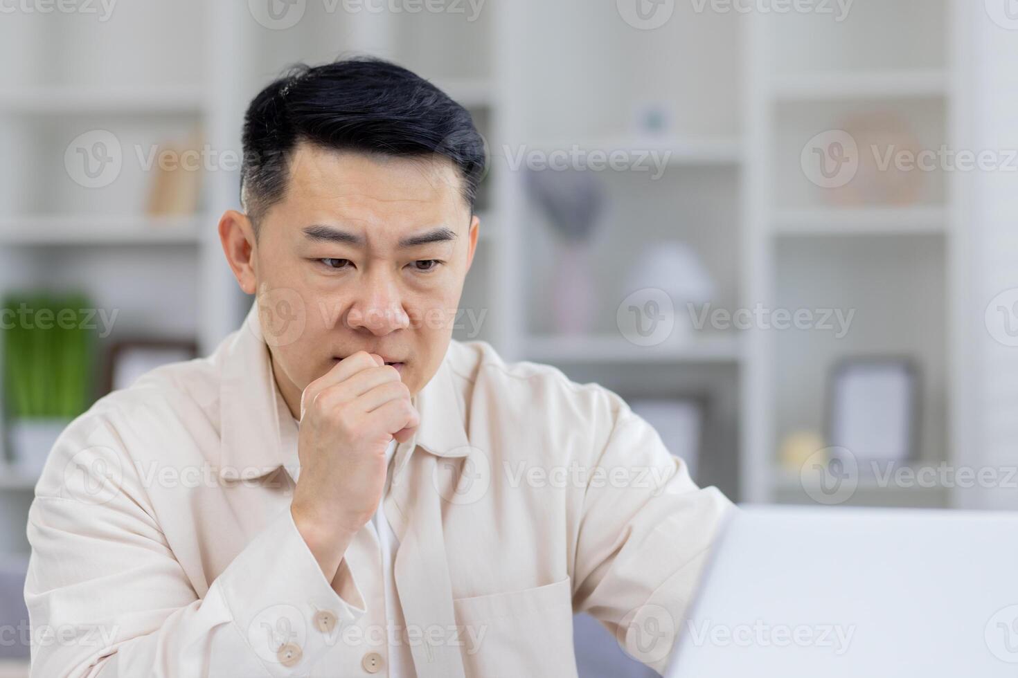 mature asiatique homme d'affaire dans réfléchi pose, séance à le sien Bureau bureau. cette image capture une moment de Profond concentration et la prise de décision dans une professionnel paramètre. photo