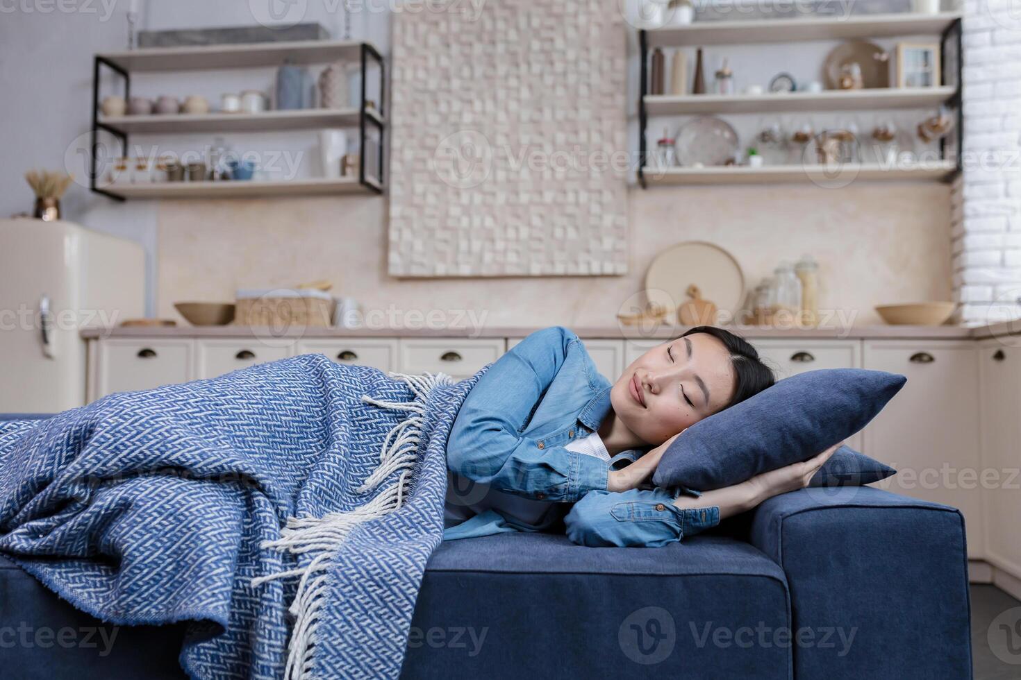 Jeune magnifique asiatique femme repos et en train de dormir à Accueil mensonge sur canapé en dessous de couverture photo