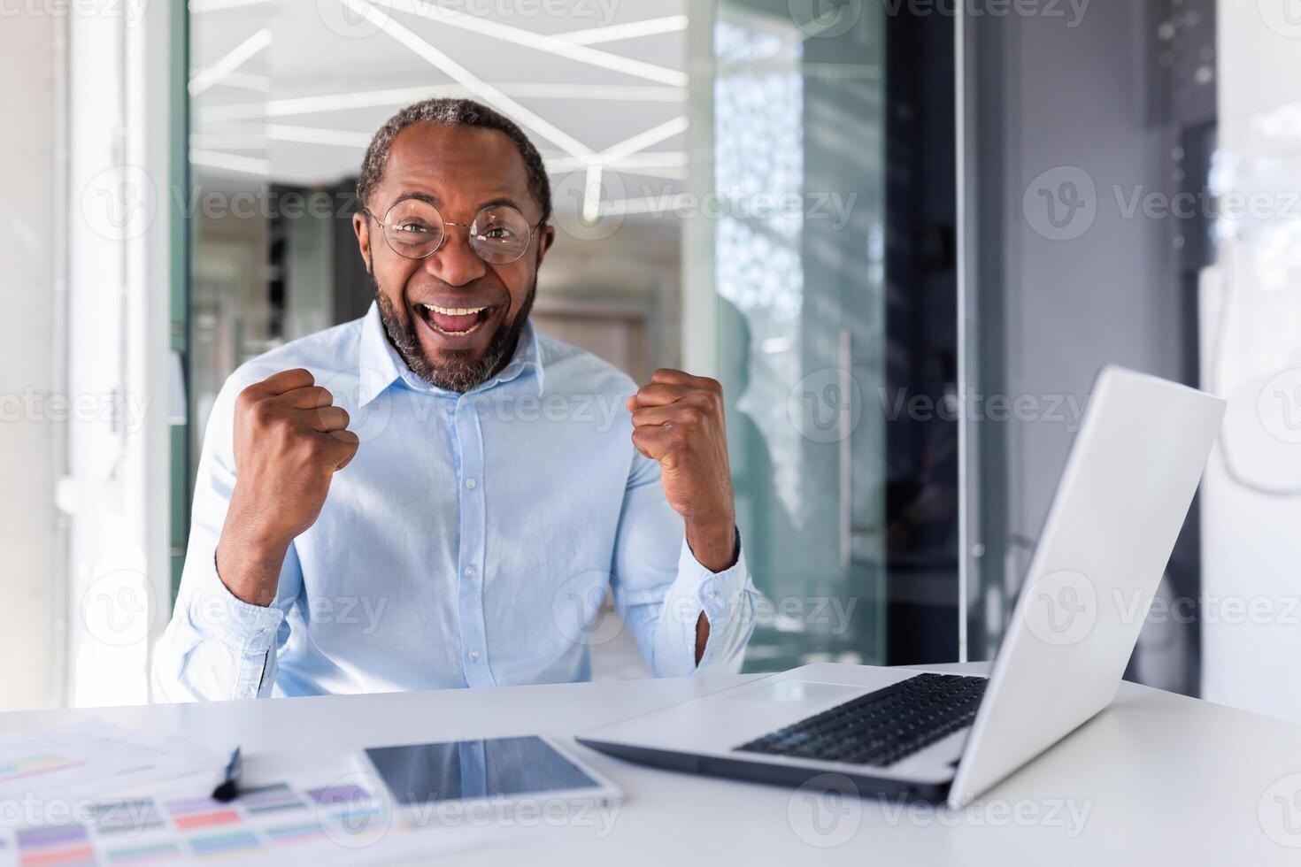 portrait de satisfait courtier investisseur, africain américain homme souriant et à la recherche à caméra, mature homme d'affaire en portant mains en haut célébrer succès, lieu de travail patron satisfait avec réussite résultats. photo