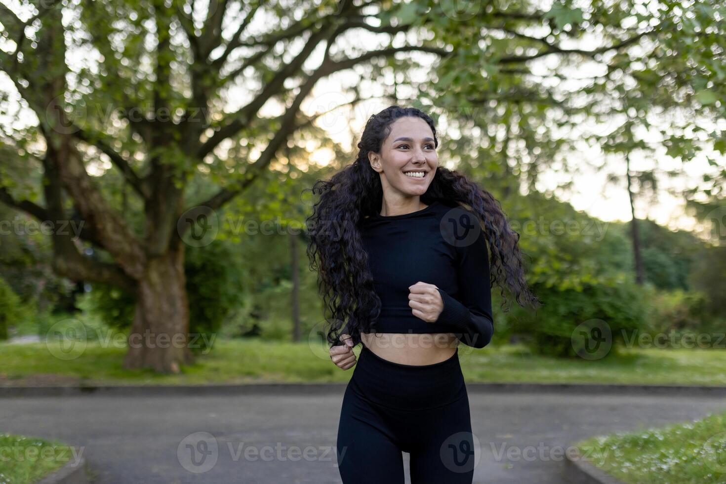 une joyeux hispanique femme dans athlétique porter fonctionnement dans une parc pendant le soir. capturé avec une concentrer sur santé, bonheur, et la nature. photo