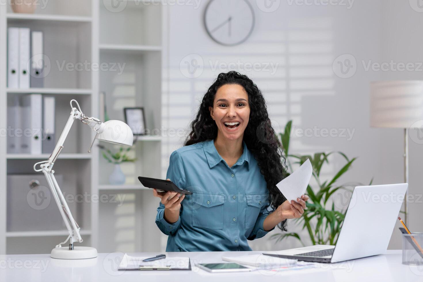 productif hispanique femme avec une joyeux expression gérant affaires Tâches de sa Accueil bureau, en portant papiers et une calculatrice. photo