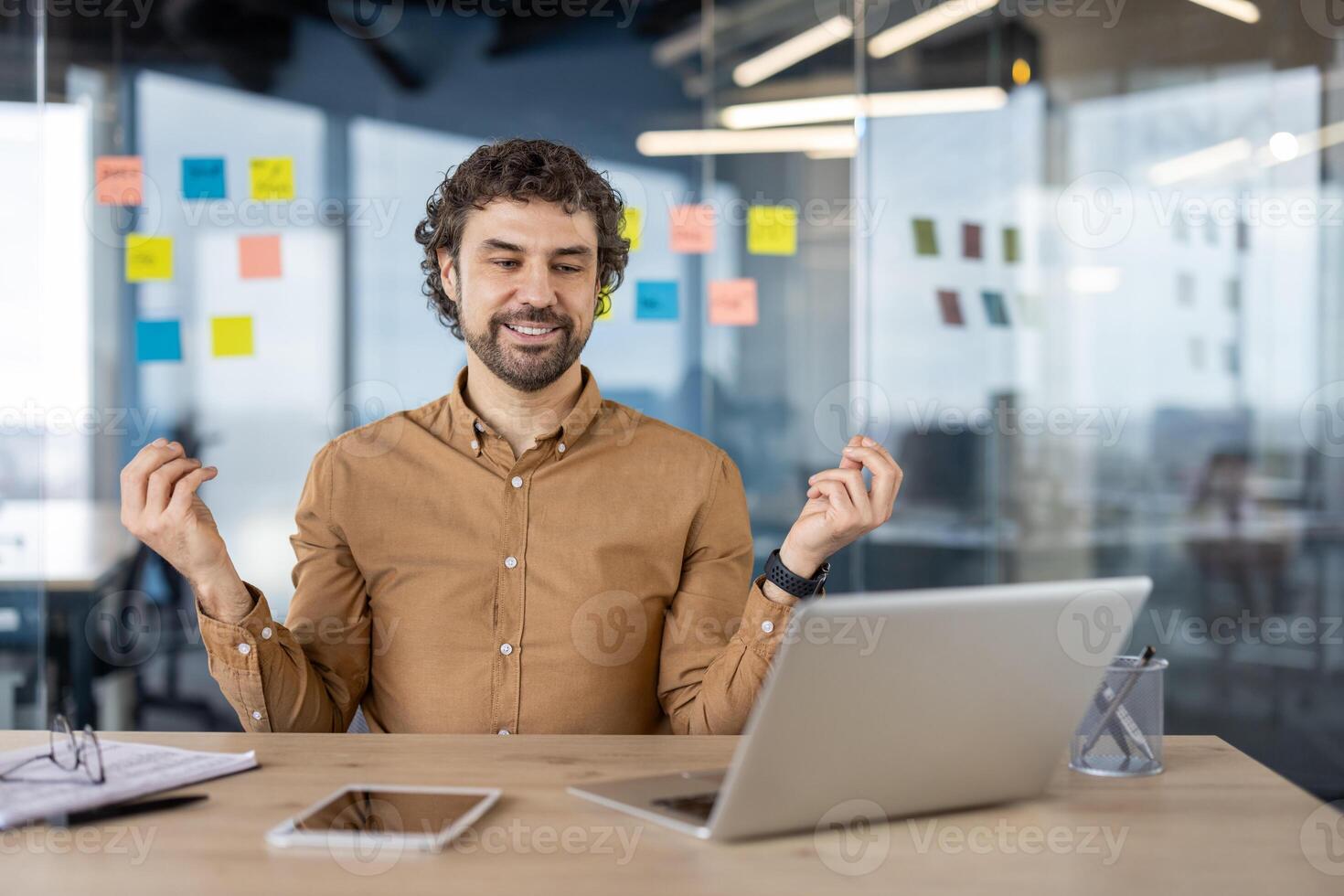 content Masculin professionnel célébrer une réussi projet dans une moderne Bureau environnement. souriant et montrant la satisfaction avec le sien réussite à travail. photo