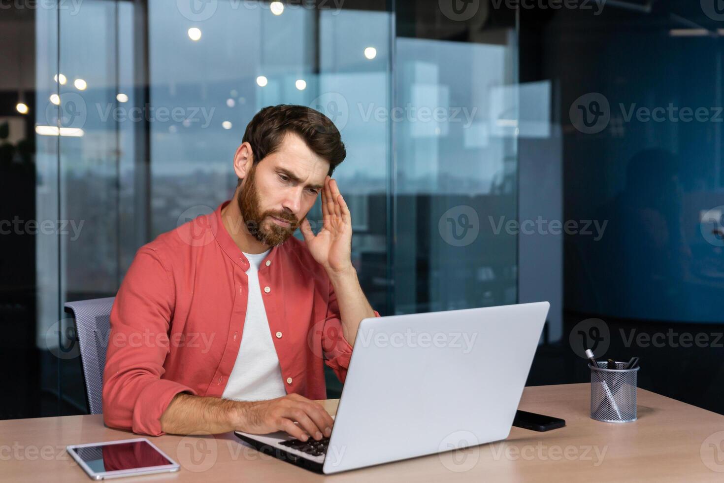 malade homme à lieu de travail, mature homme d'affaire a sévère mal de tête, patron dans chemise travaux à l'intérieur Bureau avec portable. photo