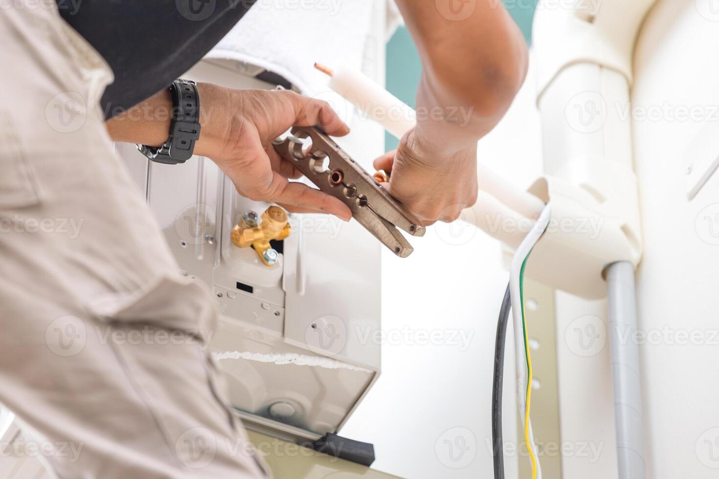 technicien homme Couper les articulations avec le outil de cuivre tuyau à réparer et installer Nouveau air Conditionneur photo
