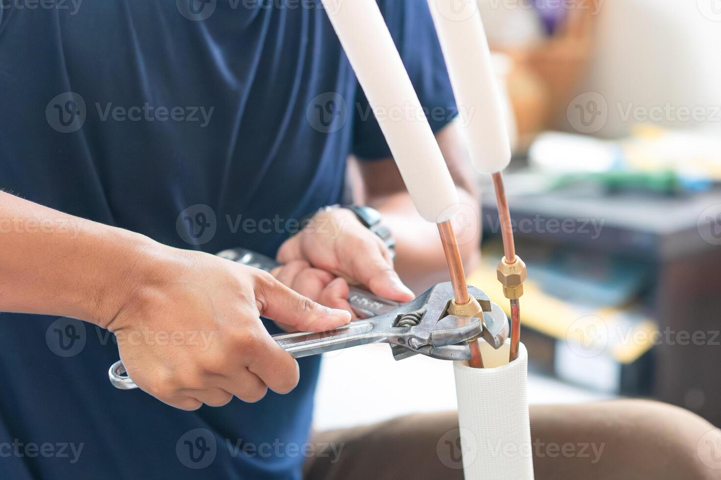 technicien homme en utilisant une clé à réparer et les articulations cuivre tuyau dans air Conditionneur système, réparation un service et installer Nouveau air conditionnement concepts photo