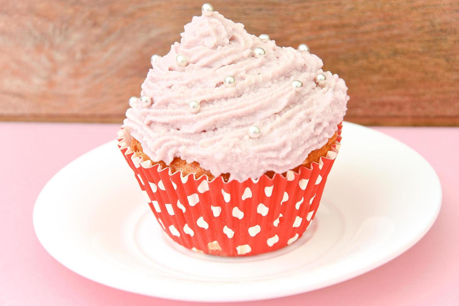 gâteau à la crème, cupcake sur fond rose. photo