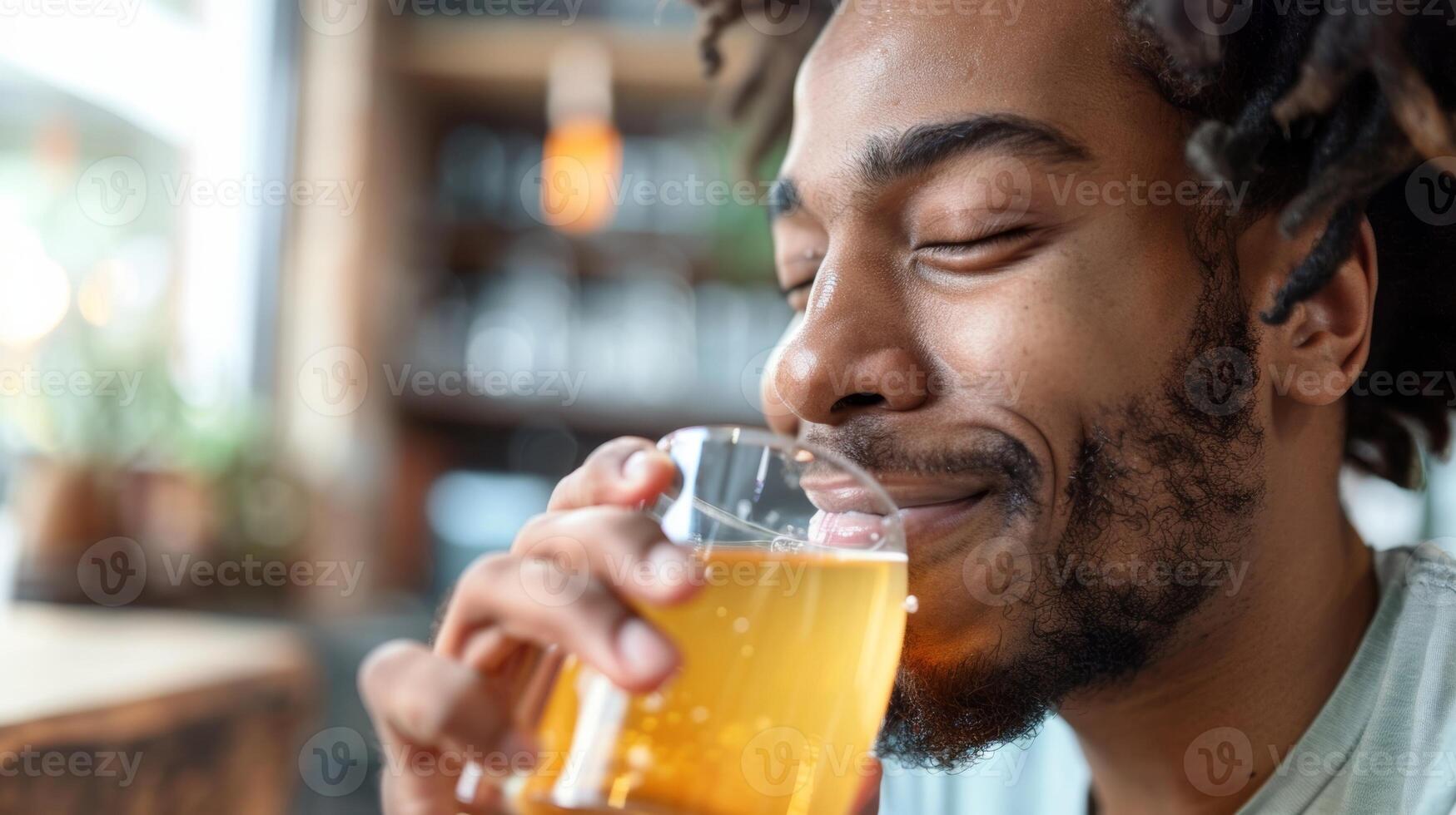 une homme prend une siroter de une lumière Jaune kombucha le sien yeux fermé dans jouissance photo