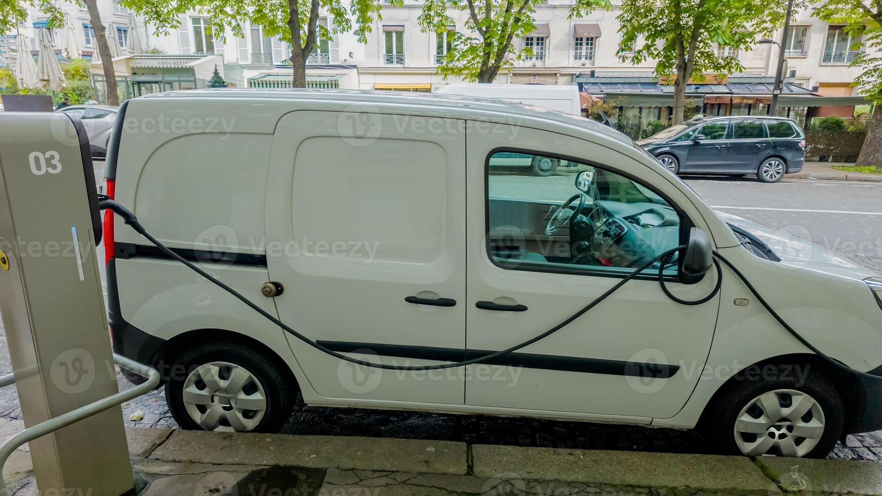 blanc électrique livraison van mise en charge à un Urbain bord de la route gare, représentant durable transport et éco amical logistique photo