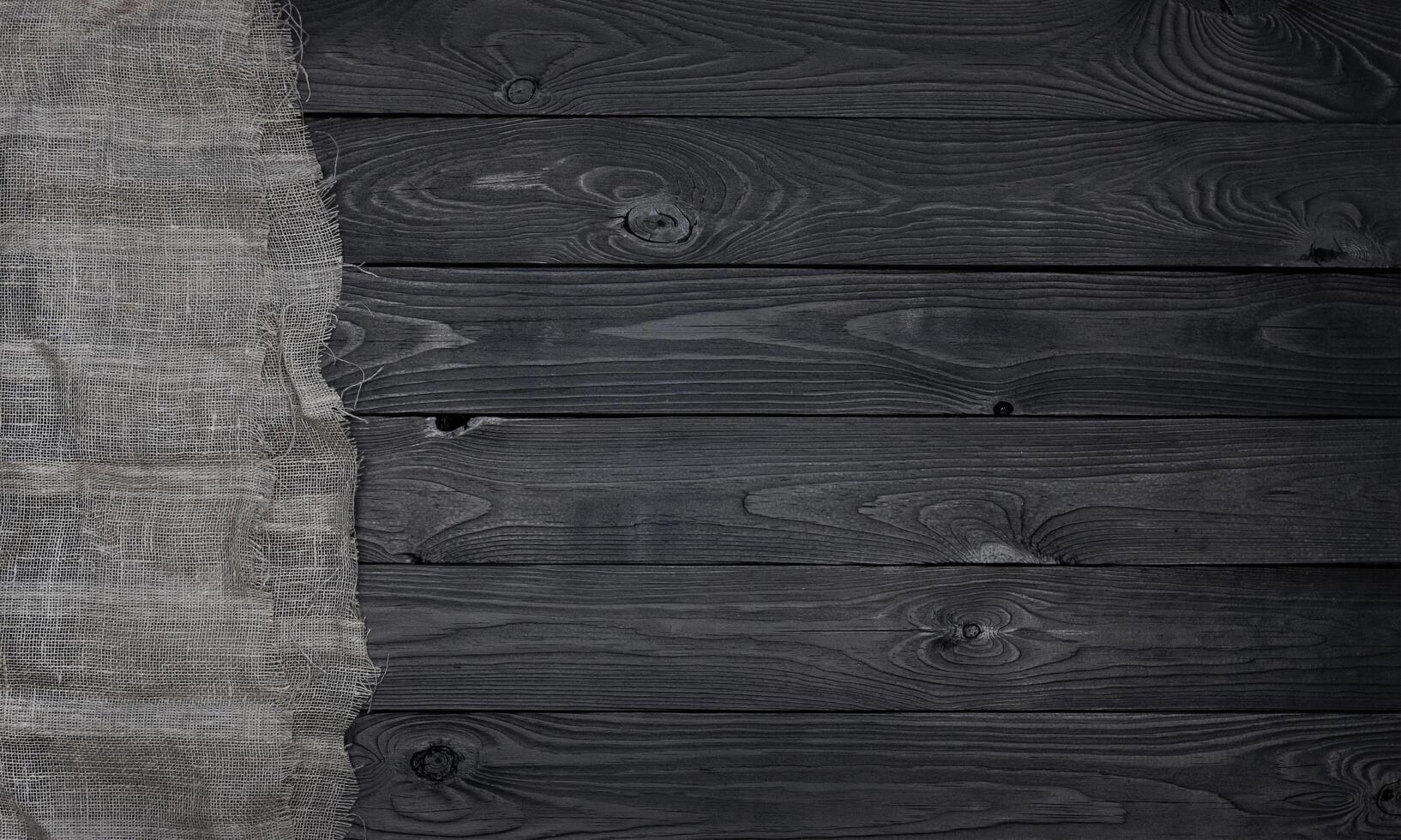 vieux toile de jute en tissu serviette de table sur noir en bois arrière-plan, Haut vue photo