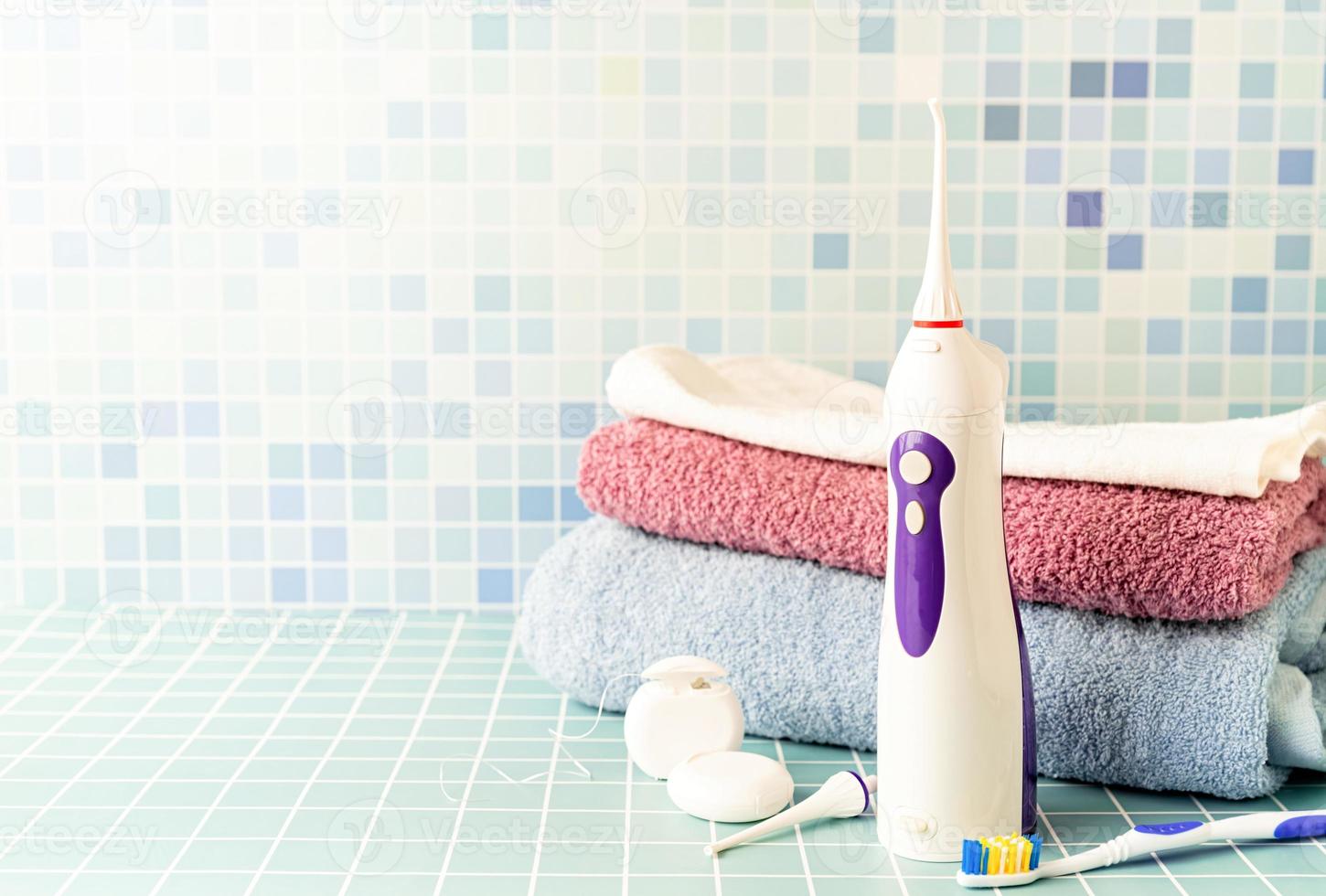 irrigateur de dents électronique, brosses à dents et un tas de serviettes vue de face copie espace photo
