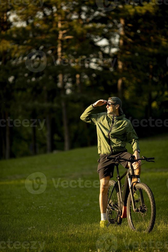 Jeune homme faisant du vélo électrique dans le parc photo