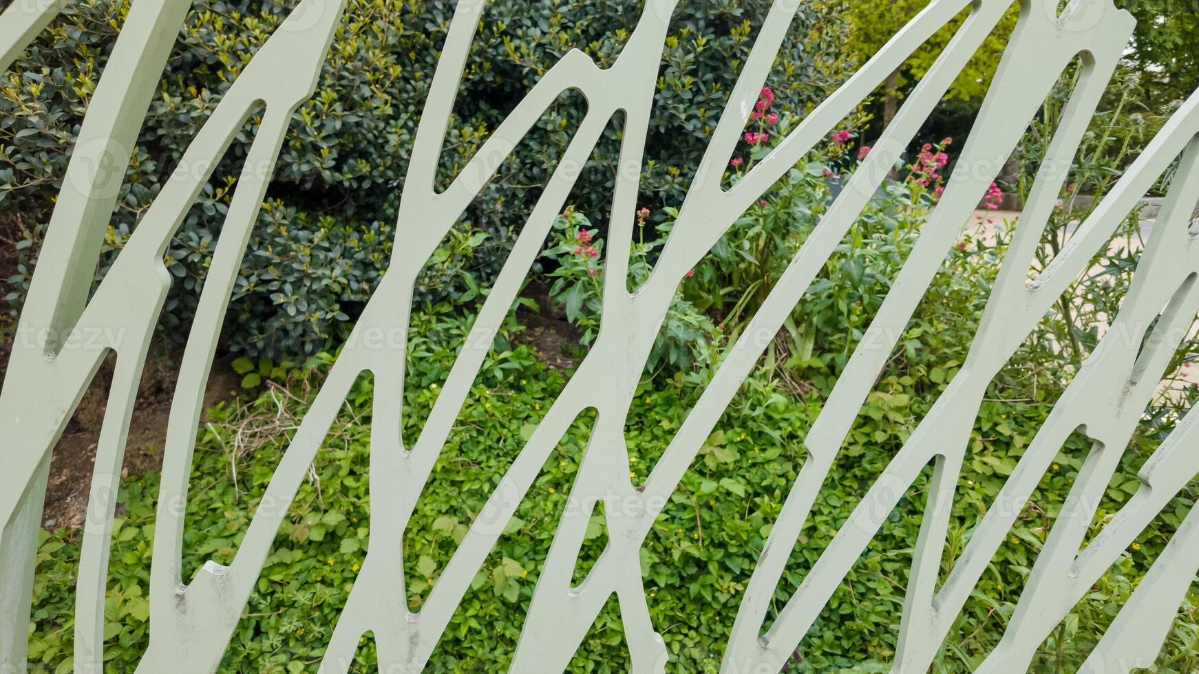 abstrait vue par une blanc artistique jardin clôture avec luxuriant verdure et épanouissement fleurs, idéal pour Accueil et jardin concepts ou aménagement paysager dessins photo
